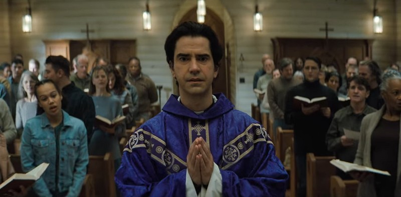 Monsignor Pruitt walks in church in Midnight Mass