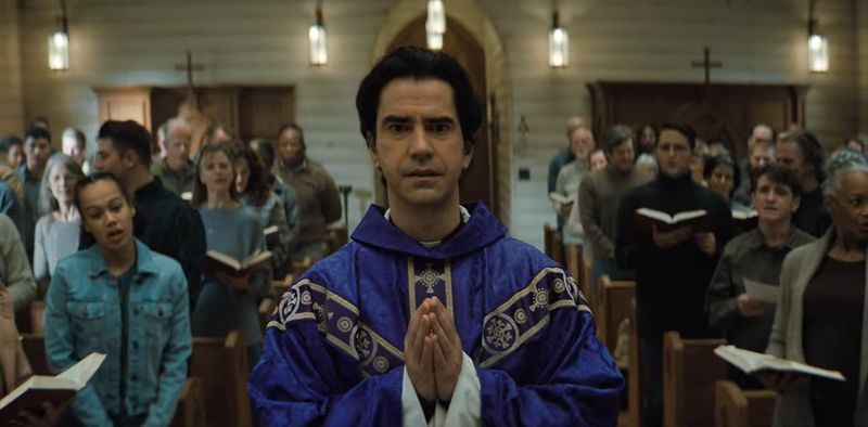 Monsignor Pruitt walks in church in Midnight Mass